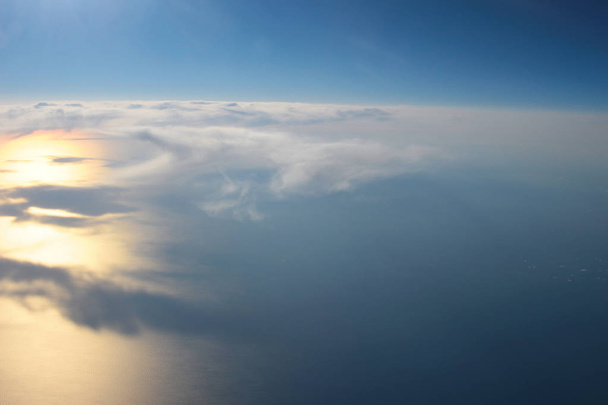 Vue au-dessus de la terre aux nuages ci-dessous
 - Photo, image