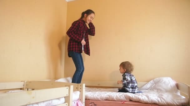 Imágenes en cámara lenta de una adolescente saltando con un bebé en la cama
 - Metraje, vídeo
