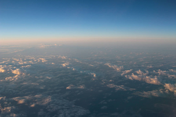 Espectacular vista de una puesta de sol sobre las nubes desde el viento del avión
 - Foto, imagen