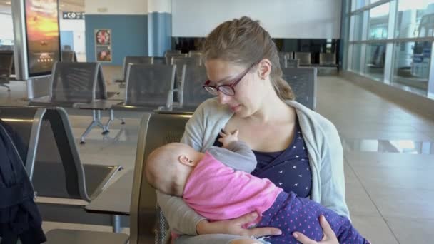 Kojící žena své dítě na letišti - Záběry, video