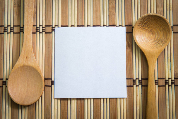Пустая бумага с деревянной ложкой на деревянном фоне, Концепция приготовления
. - Фото, изображение