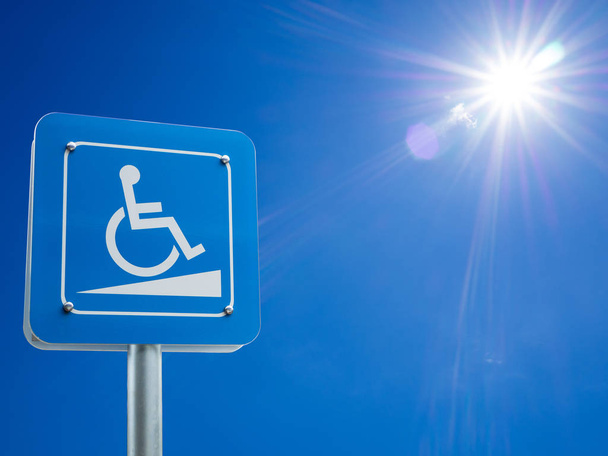 Espacio de estacionamiento para discapacitados y señal de manera silla de ruedas y símbolos en un poste de advertencia a los automovilistas
 - Foto, Imagen