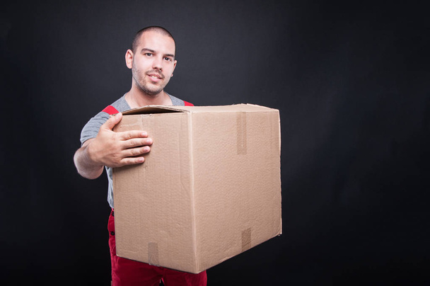 Усміхнений рушійник тримає велику картонну коробку
 - Фото, зображення
