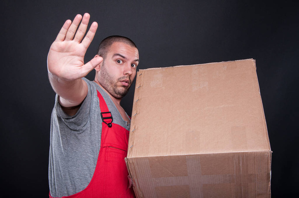 Mover homem segurando caixa fazendo parar gesto
 - Foto, Imagem