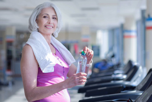 woman with towel and water at gym - Foto, Imagen