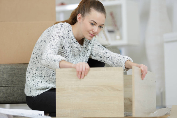 woman in shirt assemble furniture - Фото, изображение