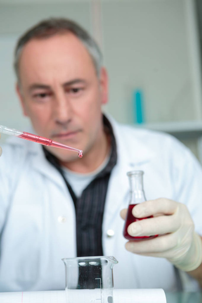 male scientist using chemistry fluid for research in laboratory - Φωτογραφία, εικόνα
