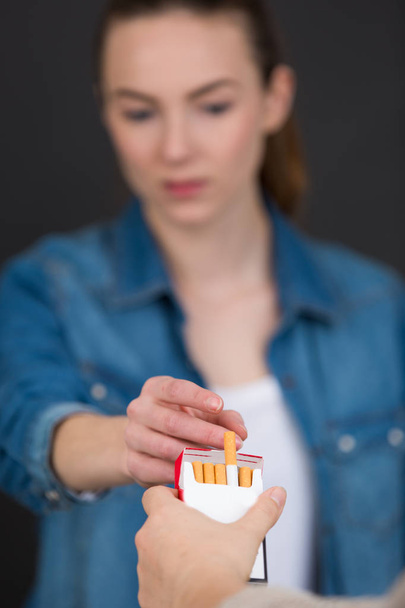 female takes a cigarette from the pack - Photo, image