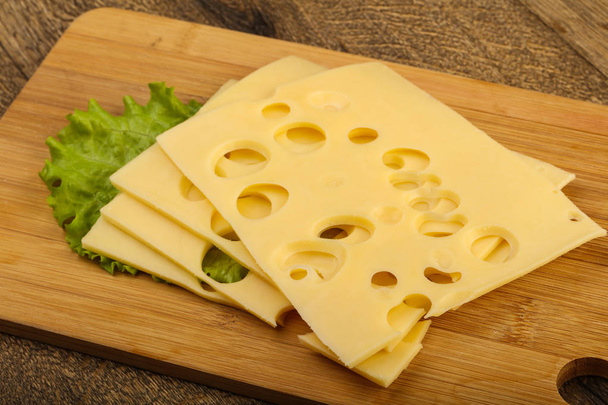 Κομμένο σε φέτες τυρί με φύλλα σαλάτας - Φωτογραφία, εικόνα