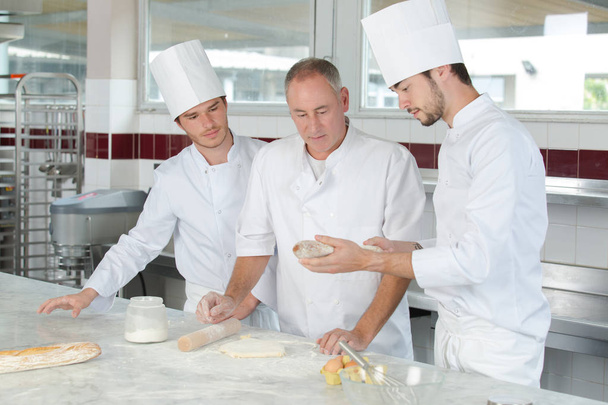 pastry chef watching students preparing delicious pastries - Φωτογραφία, εικόνα