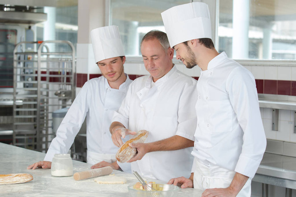 apprentices in bakery learning from experienced professional - Фото, изображение