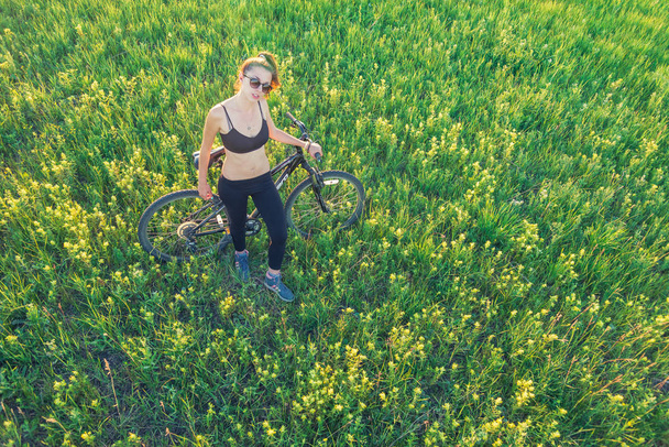 Girl riding a mountain bike in the field - Foto, Imagem