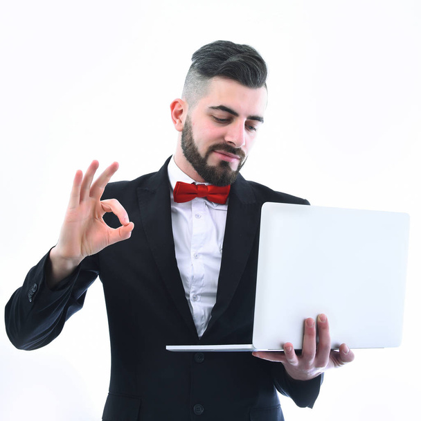 Empresario o locutor de televisión muestra signo OK y sostiene el ordenador portátil
 - Foto, imagen