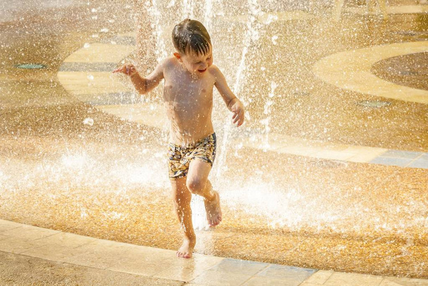 Щаслива дитина насолоджується грою у воді в літню спеку
. - Фото, зображення