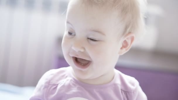 ein süßes kleines Mädchen blickt in die Kamera und lächelt - Filmmaterial, Video