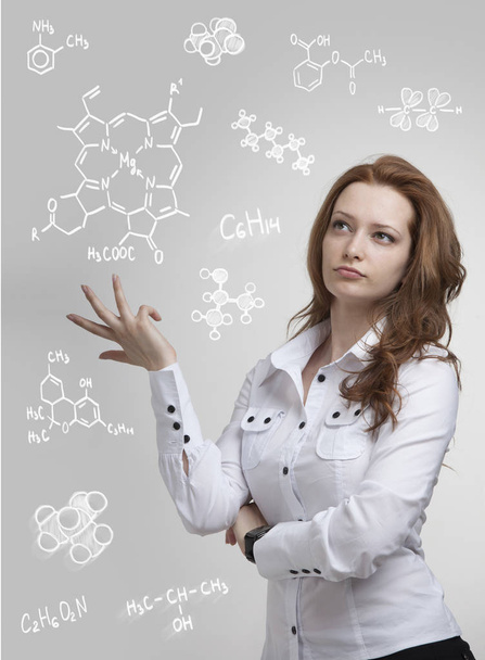 Woman chemist working with chemical formulas on grey background. - 写真・画像