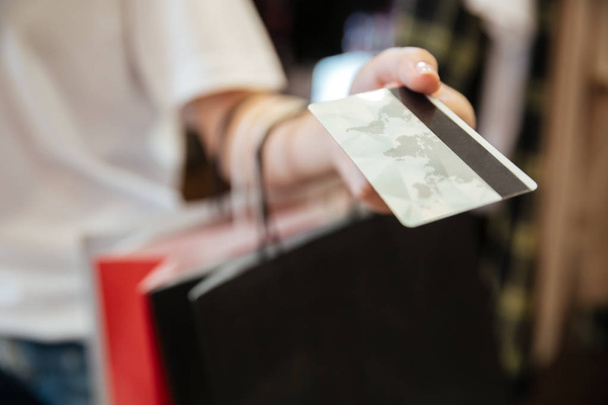 Cropped image of young woman holding debit card. - Photo, Image