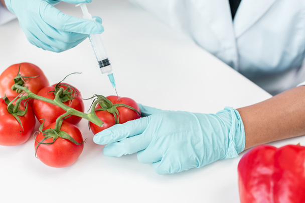 Wissenschaftler mit Spritze und Tomaten - Foto, Bild