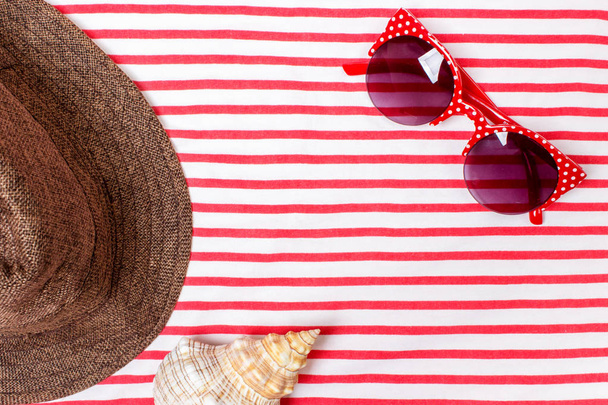Summer vacation, tourism, travel, holiday concept. Sea shells, beach hat and striped blanket in white. Top view with space for text. - Photo, Image