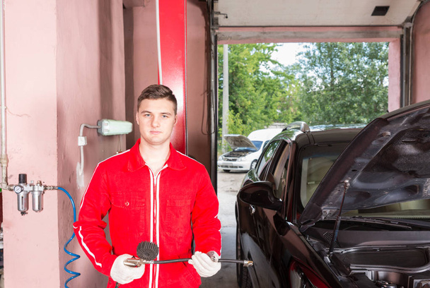 junge hübsche männliche Automechaniker halten Ausrüstung für die Überprüfung - Foto, Bild
