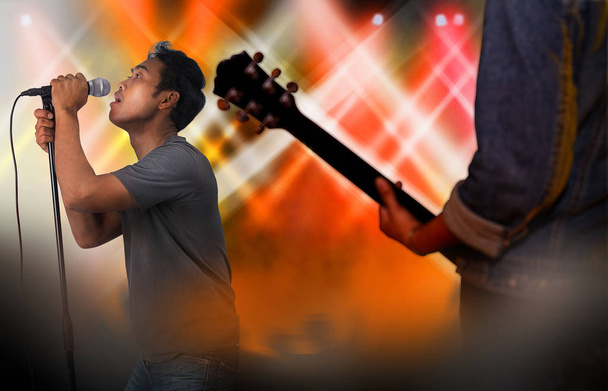 Σιλουέτα του ηλεκτρικός κιθαρίστας και τραγουδιστής σε μια σκηνή, ζωντανά - Φωτογραφία, εικόνα