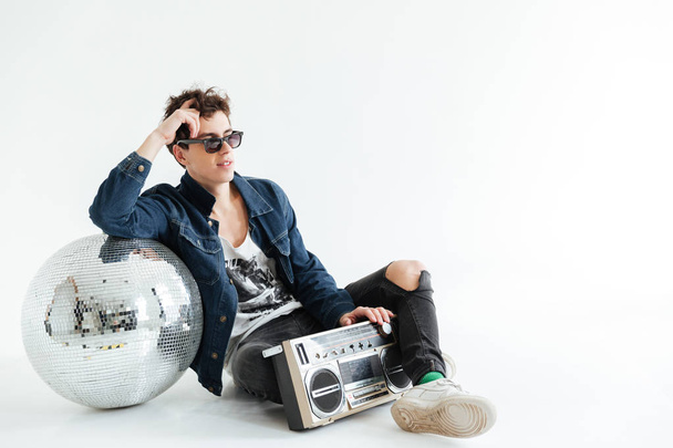 Handsome young man near disco ball and boombox - Foto, afbeelding