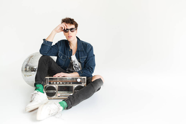 Serious young man with disco ball and boombox. - Photo, Image