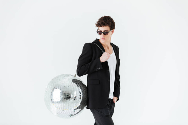 Side view of man in suit carrying disco ball - Φωτογραφία, εικόνα