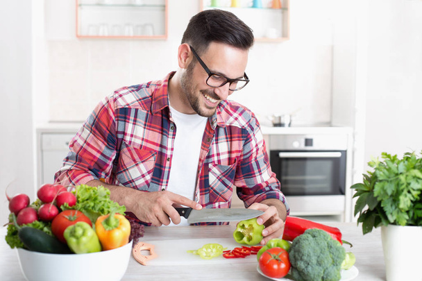 Man chopping vegetable in kitchen - Photo, Image