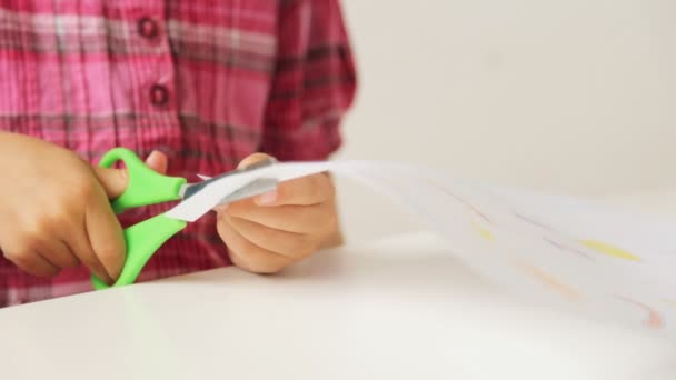 Ruce dítěte řezání papíru s nůžkami - Záběry, video