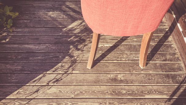 Modern vörös szék, a kopott fa padló, a nyári napfény - Fotó, kép