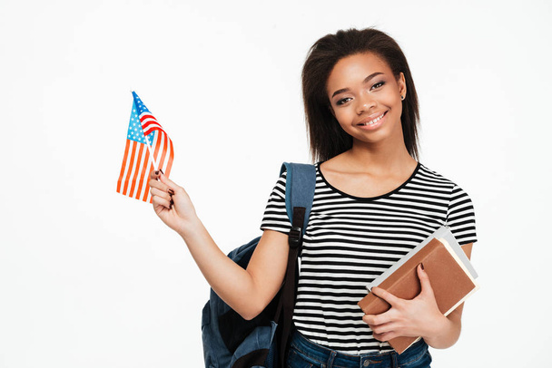 Lány diák hátizsák gazdaság könyvek és az amerikai zászló - Fotó, kép