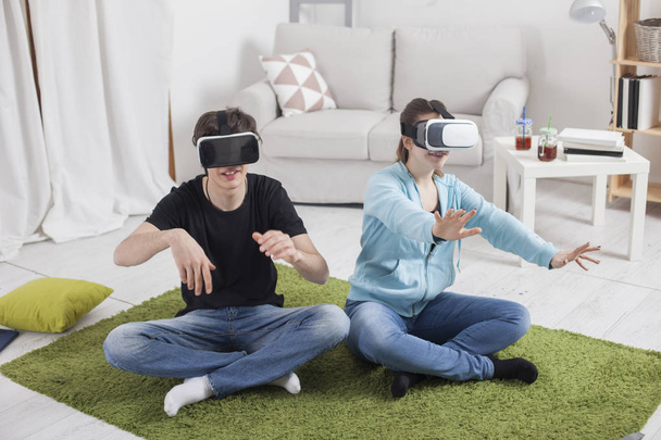 Realidad virtual. Adolescentes con gafas virtuales están jugando en la l
 - Foto, Imagen