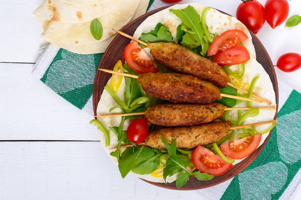 Gehakt op Spies - lula kebab op een bord met verse groenten - Foto, afbeelding
