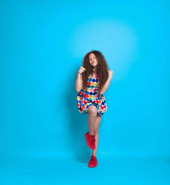 Girl with curly hair posing in studio - Fotó, kép