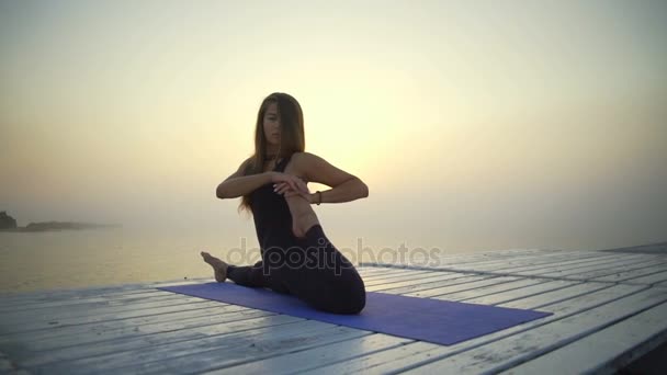 junges Mädchen schlanke schwarze Kleidung Yoga Pose Sonnenaufgang Nebel schnelle Zeitlupe - Filmmaterial, Video