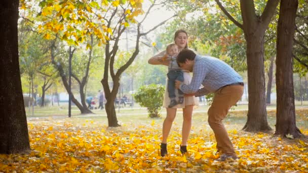 Filmagem em câmera lenta do jovem pai feliz correndo para sua esposa com o bebê e abraçando-os no parque
 - Filmagem, Vídeo