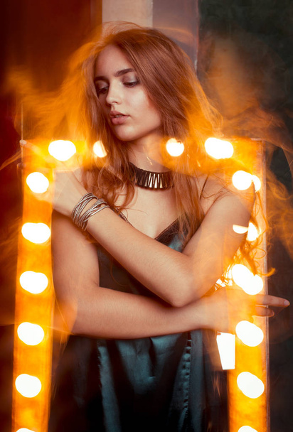 luxuriöse junge Dame tanzt in gemischtem Licht im Studio - Foto, Bild