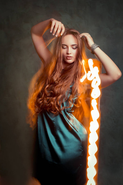 Mujer joven glamurosa bailando en luz mixta en el estudio
 - Foto, Imagen