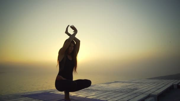 Dívka slim černé oblečení lotus meditovat jóga pozice sunrise mlha rychlý Zpomalený pohyb - Záběry, video