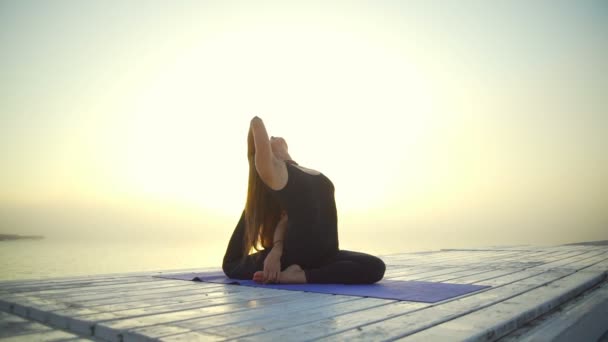 Gezonde jonge meisje slank zwarte slijtage doen yoga pose zonsopgang mist snelle langzame motie - Video