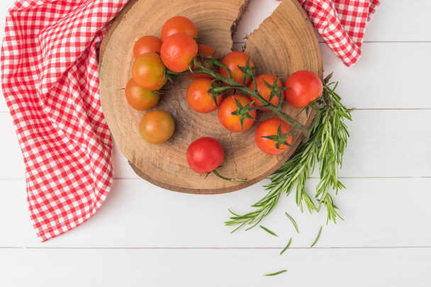 Organic cherry tomatoes with rosemary on rustic wooden table - Zdjęcie, obraz
