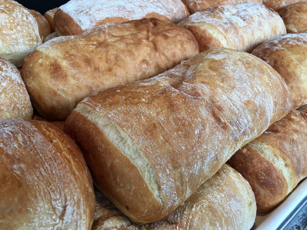 Panes frescos calientes en una exhibición del estante de la panadería
 - Foto, Imagen
