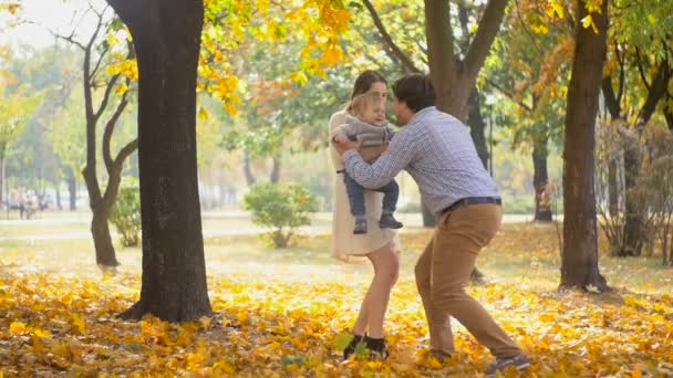 Boldog apa fia baba fut, és emeli a levegőben őszi park lassú mozgás hosszúság - Felvétel, videó