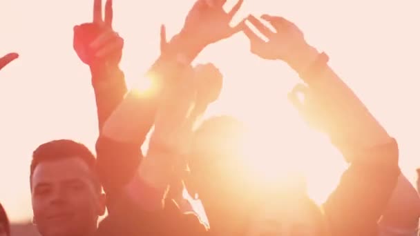 Gruppe von Menschen, die draußen im Sonnenlicht tanzen und die Hände heben. Zeitlupenaufnahme. - Filmmaterial, Video
