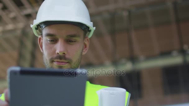 Male Engineer Using Tablet Computer. Glass Building or Skyscraper under Construction on Background. - Filmmaterial, Video