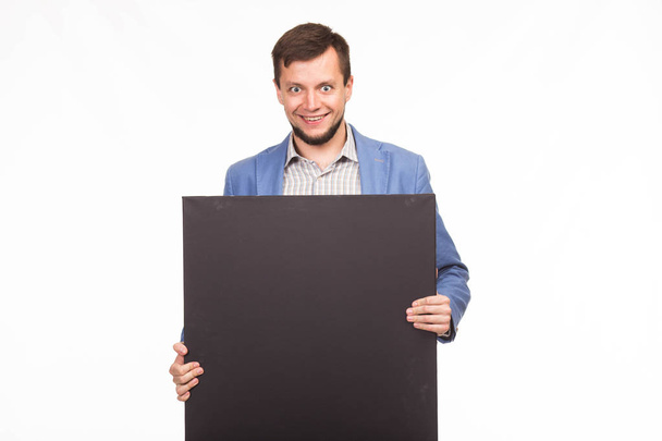 Young happy man showing presentation, pointing on placard - Zdjęcie, obraz