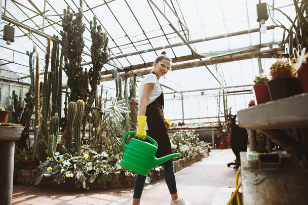 Happy young lady in glasses standing in greenhouse - Foto, Imagem