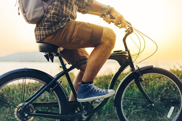 Unrecognizable Young Hipster Man Is Cycling Along The Shore Against The Backdrop Of The Sunset Vacation Holiday Activity Concept - Foto, Imagem