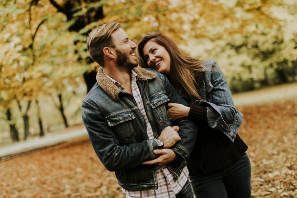 秋の公園で抱き合って笑ってるカップル - 写真・画像